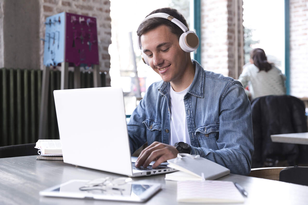 Jovem assiste aula online no notebook