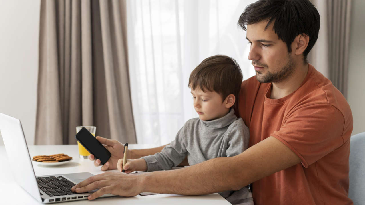 Homem com criança usando notebook para fazer matrícula online MA em 2025