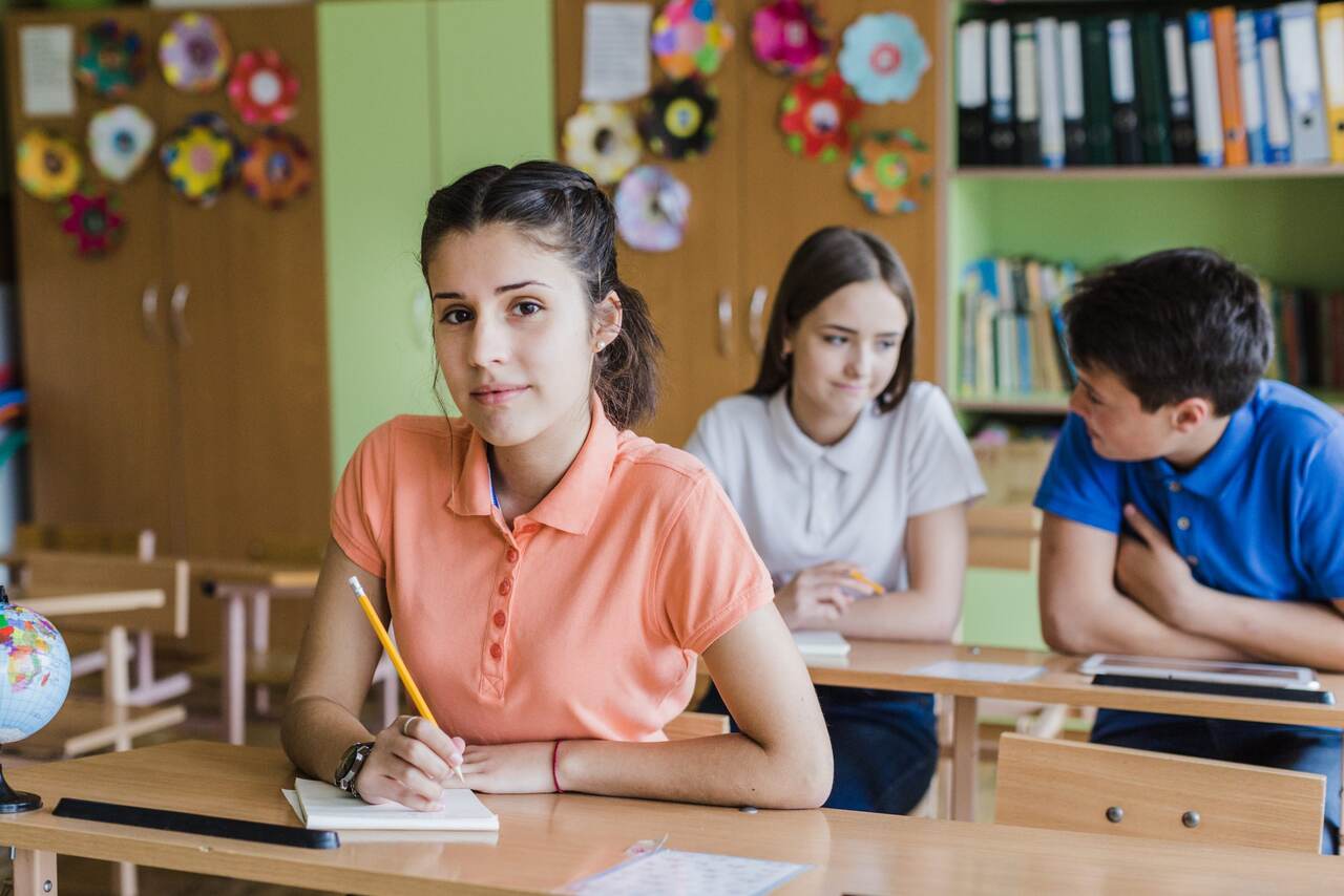 Adolescentes fazem tarefa na sala de aula 