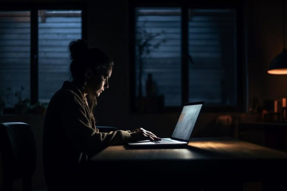 Uma menina estuda em frente ao seu notebook. Ela estuda no escuro para o Vestibular UEA 2025