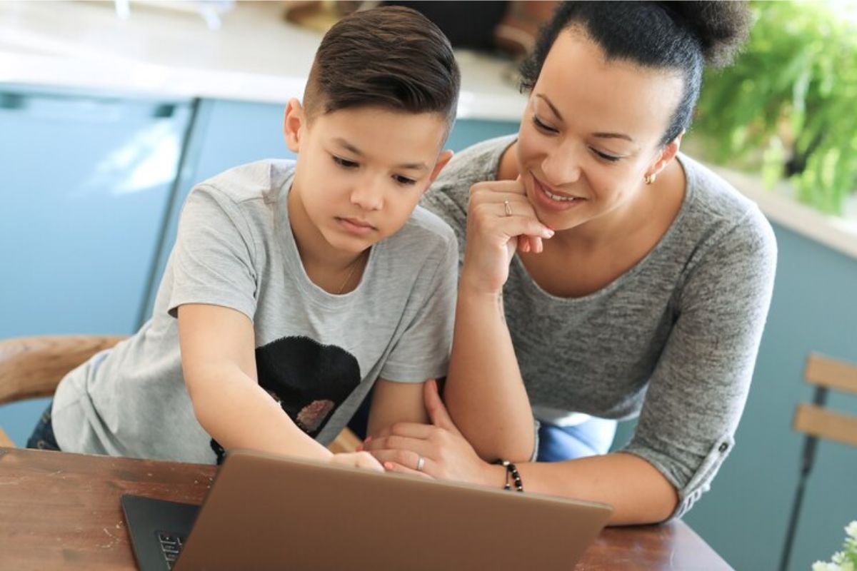 Uma mãe ao lado de seu filho em frente ao notebook enquanto fazem a matrícula online Porto Velho 2025