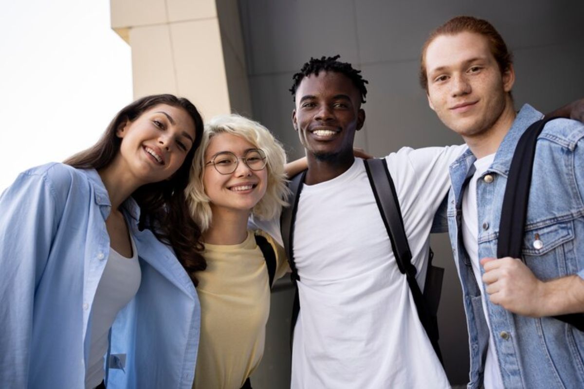 Um grupo de quatro estudantes posa para a foto junto