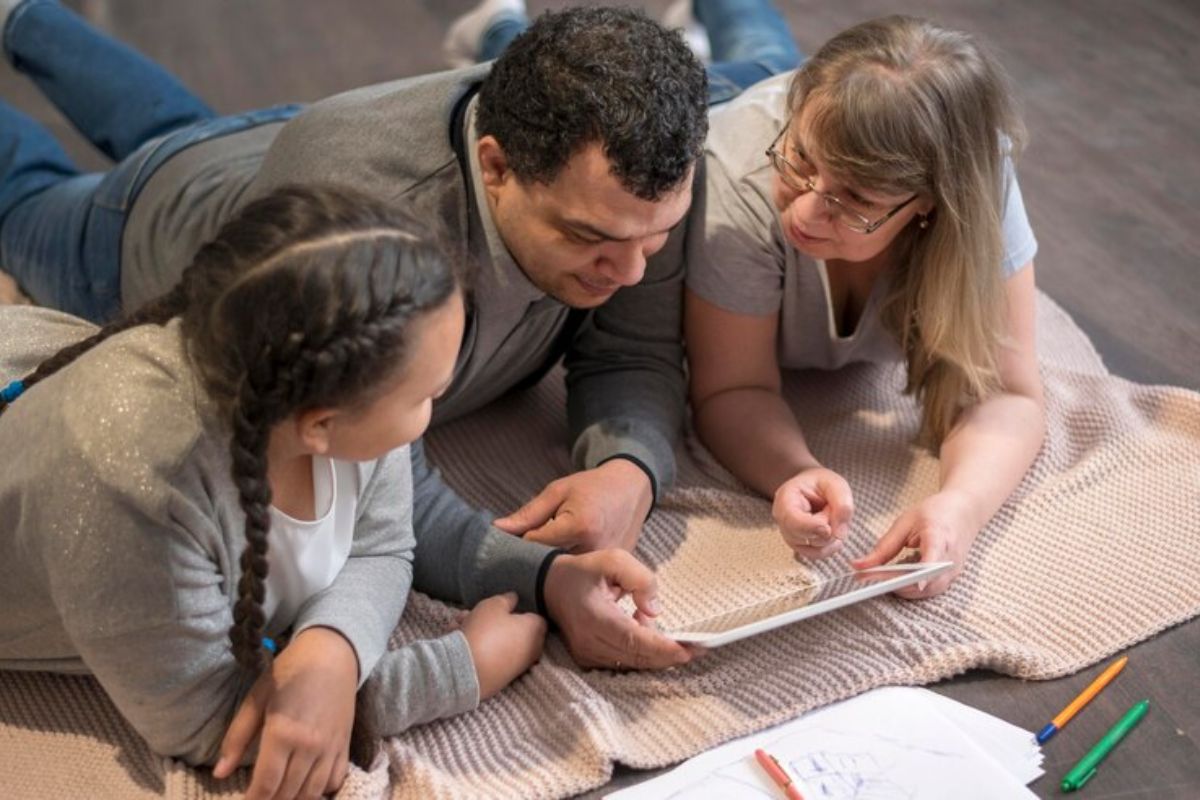 Uma família usando um tablet: mãe, pai e filha