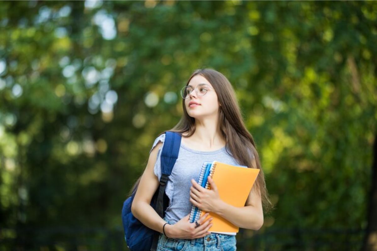 Uma estudante com seus materiais na mão