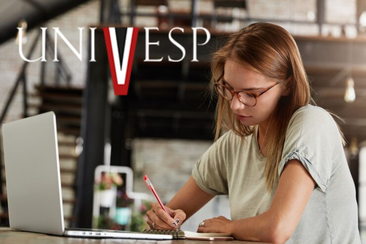 Uma menina em frente ao notebook escreve em seu caderno enquanto se prepara para participar das Matrículas Univesp 2025