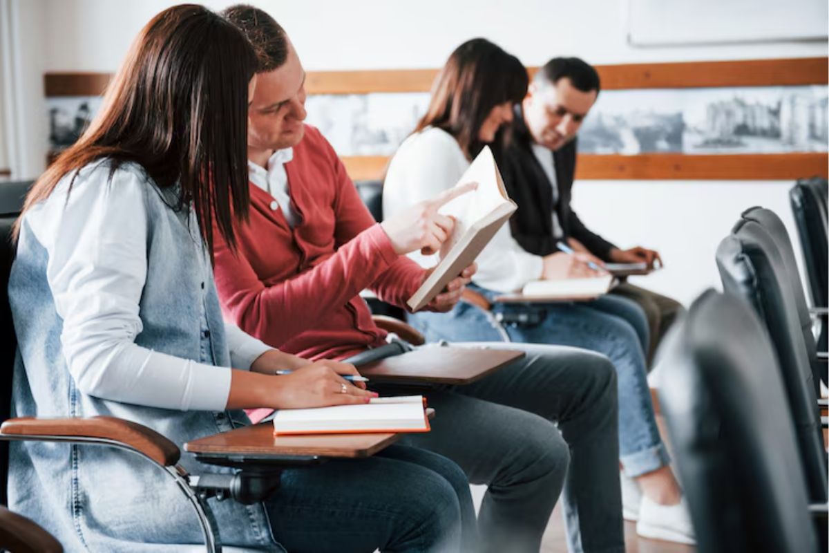 Um grupo de estudantes na sala de aula. Dois deles conversam após as Matrículas Unioeste 2025