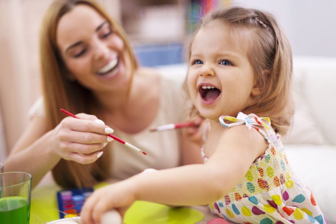 Professora realiza atividade de pintura com bebê na creche 