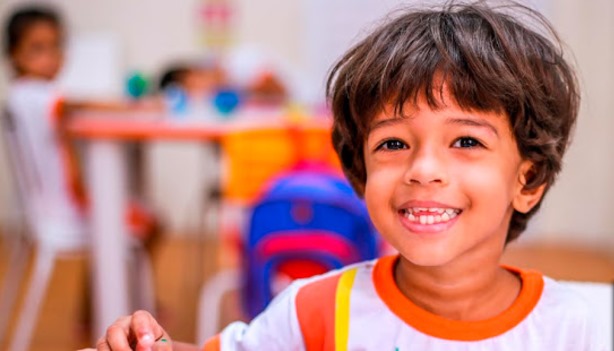 Criança sorridente em sala de aula