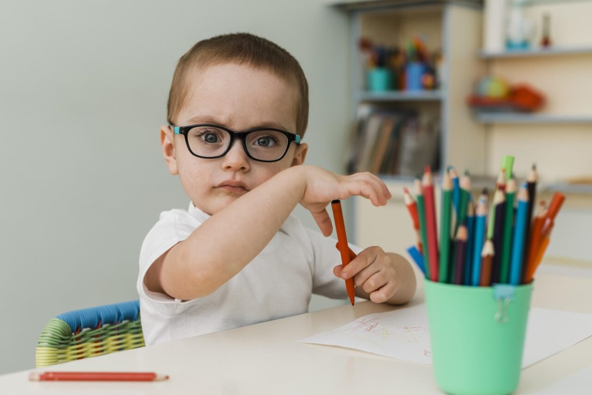 Criança pintando em sua mesa na creche 