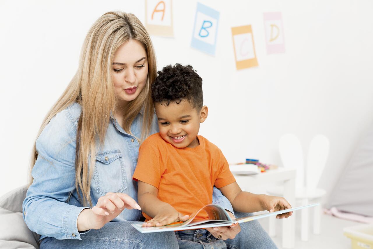 Professora de creche lê com aluno