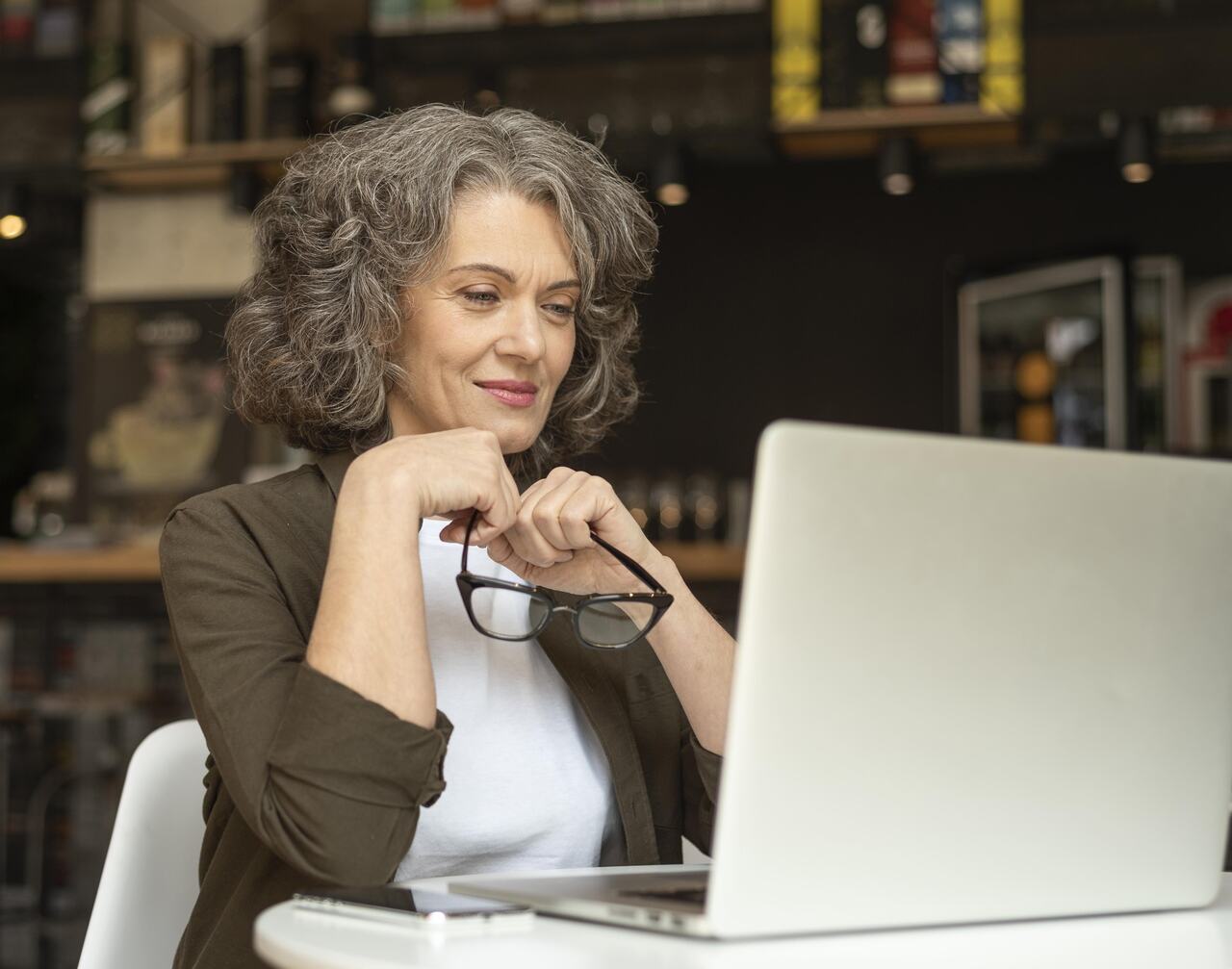 Professora assiste aula online em seu notebook 